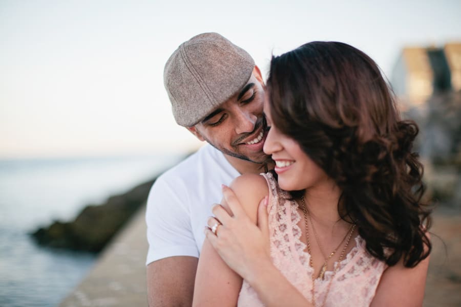 Couple embraces at Point Pleasant inlet during their engagement photo session with their monmouth county nj wedding photographers markow photography